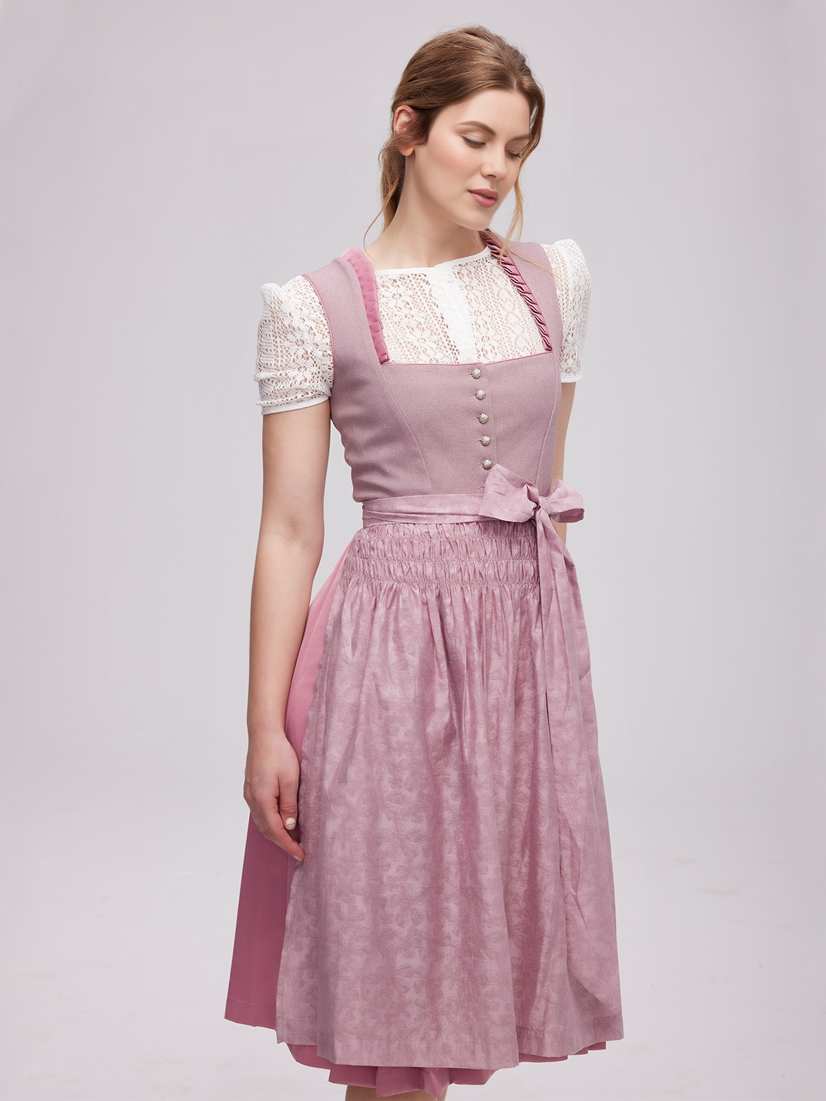 Lila Dirndl mit kunstvoller Schürze
